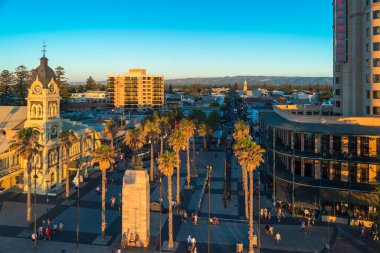 Adelaide, Güney Avustralya - 12 Ocak 2019: Glenelg Plajı 'nda gün batımında yürüyen insanlar Moseley Meydanı' ndaki Giant Ferris Wheel 'den izlediler.