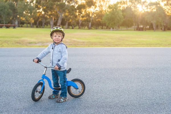 南オーストラリアのアデレードパークランドで日没時にバランスバイクに乗る男の子 — ストック写真
