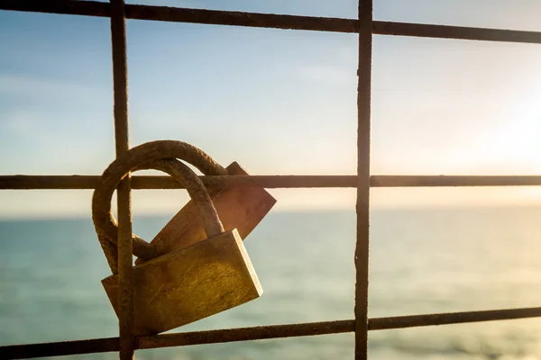 Roestige liefde sloten opknoping op het hek als een symbool van loyaliteit en — Stockfoto