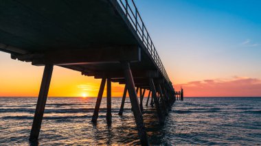 Glenelg Sahili 'nde dramatik bir gün batımı. İskeleli siluet ve parlayan ufuk, Adelaide, Güney Avustralya.