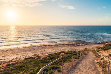 Blanche Point Koyu, Fleurieu Yarımadası, Güney Avustralya 'daki sahile giden manzaralı günbatımı yolu.