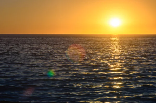 Günbatımı okyanus lens ile yukarıda fişekleri — Stok fotoğraf