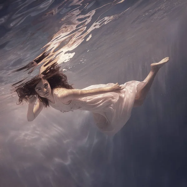 Egy Lány Fehér Ruhában Hosszú Sötét Hajjal Úszik Víz Alatt — Stock Fotó