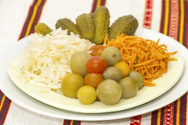 Ein Teller mit eingelegten Gurken, Tomaten, Karotten und Kohl — Stockfoto