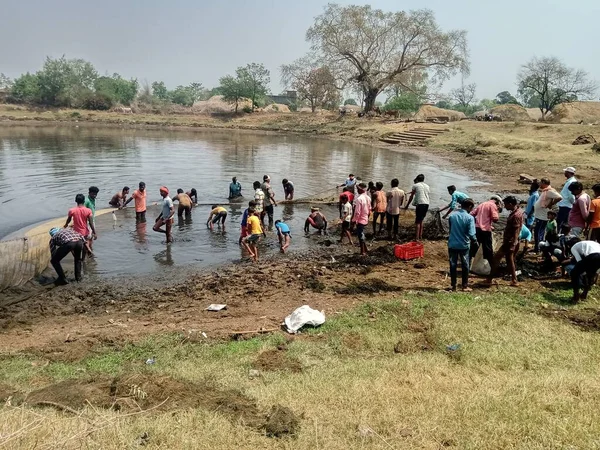 Hint köylüleri balık çiftliğinde çamurda çalışıyor.