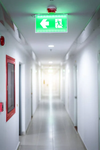 hallway in apartment with , door rooms in dorm Fire exit green light sign