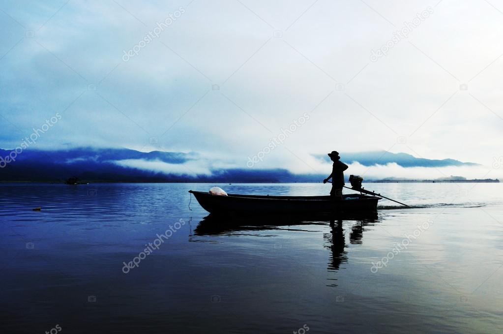 Silhouette of fishermen with his boat