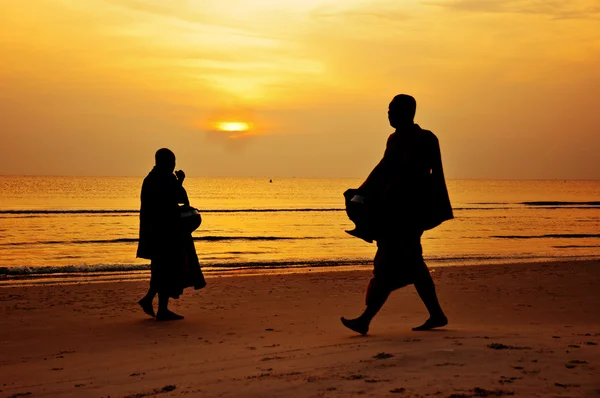 Silhuett av munken promenad på stranden — Stockfoto