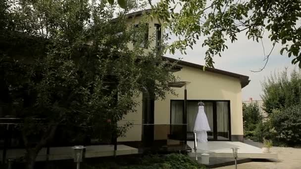 Apple orchard, a house and a wedding dress on the veranda. — Stock Video