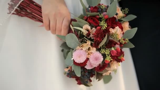 Kleurrijke rood witte bruiloft boeket in handen van de bruid — Stockvideo