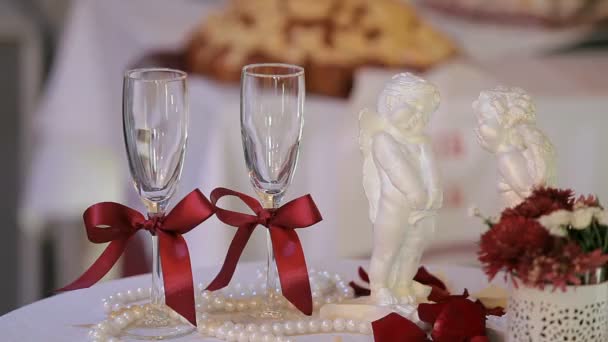 Esküvői poharak, a háttérben a két fehér kerámia angyalok. — Stock videók