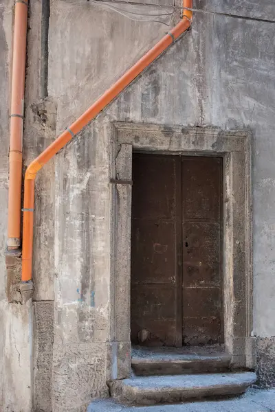 壁の古い錆びた暗い家のドアと下水道 — ストック写真