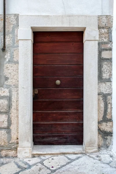石の壁に木製の茶色のドア アパートへの入り口 — ストック写真