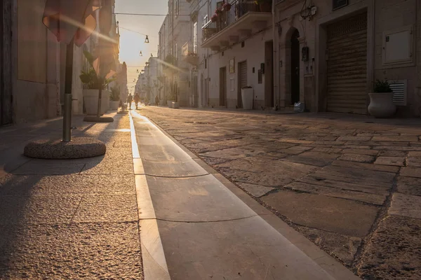 Street lit by the light of the rising sun. Polignano, Italy.