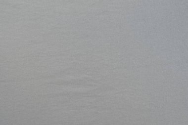 Dokulu yüzeyi olan homojen gri bir arkaplan. Gri kumaş.