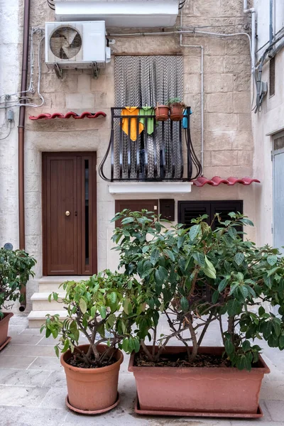 Konforlu küçük bir avlu, apartmanın kapısı, balkon, saksı bitkileri, klima. Positano, İtalya.