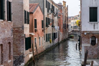 Eski evler arasında kanal daralıyor. Kemer köprüsü. Venedik, İtalya.