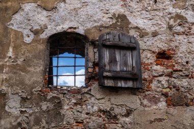 Pencereyi parmaklıklar ve panjurlarla açın. Riga, Letonya 'da eski tuğla bir bina..