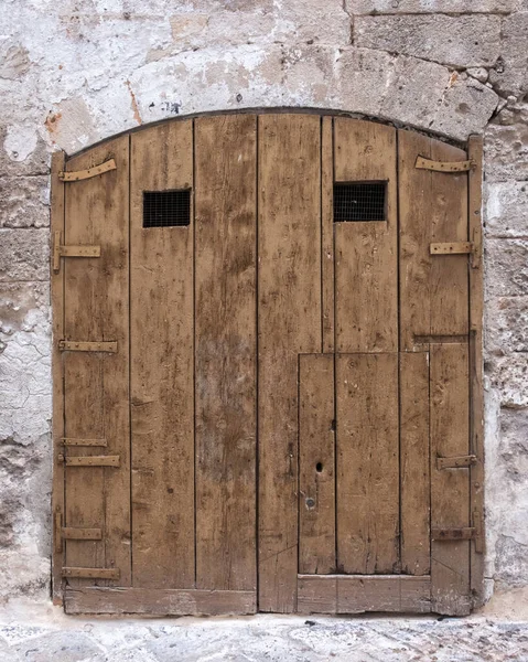 Stare Zamknięte Drewniane Drzwi Łuk Kamiennej Ścianie Małe Okna Włochy — Zdjęcie stockowe