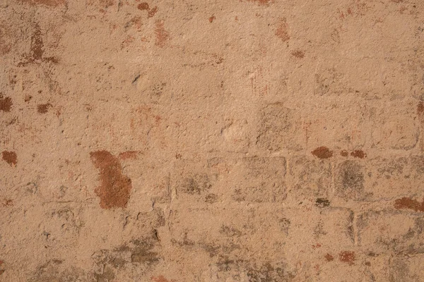 Stucco taş duvarı. Kırmızı - turuncu boya, arka plan, yakın plan.