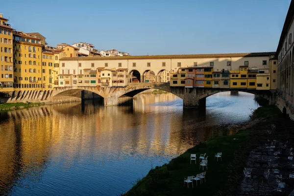 Ünlü Ponte Vecchio köprüsü, gündoğumu ve sudaki binaların yansıması. Floransa. İtalya.