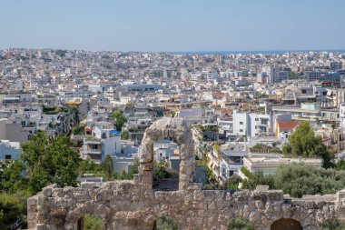 Güneşli bir günde Atina şehri, Akropolis tepesinden manzara. Beyaz evler ve mavi deniz.
