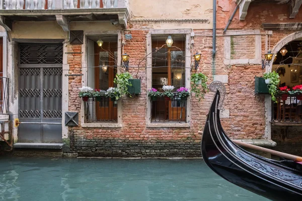 Venedik 'te kanal, eski bir evin duvarı. Güzel pencereler ve bir gondol parçası..