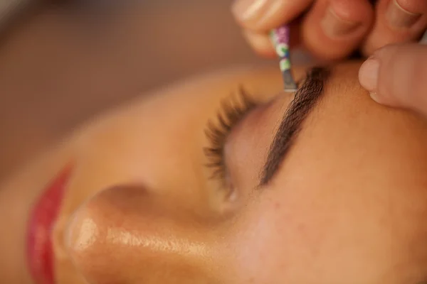 woman plucking eyebrows