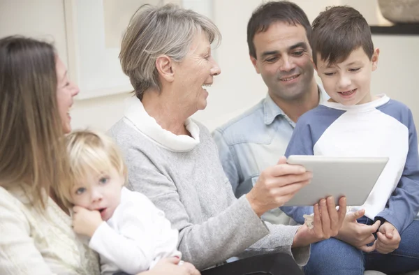 family sitting on sofa with tablet