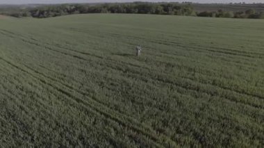 İsrail askeri üniformalı genç bir adam yeşil bir sahanın ortasında dua ediyor. O tefillin ve tallit giyiyor. Kameralar daire çiziyor. Uzak plan