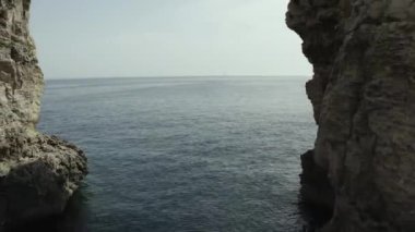 İnsansız hava aracı uçuyor. İnsanların yüzdüğü berrak mavi suyun üzerinde uçuyor