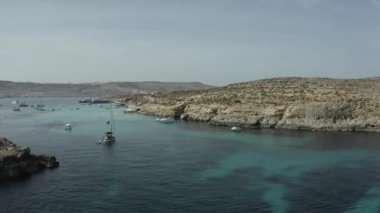 İnsansız hava aracı büyük bir insan grubunun üzerinde kristal berrak suda yüzer.