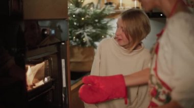 Anne ve güzel kızı mutfakta hamur işleri hazırlıyorlar. Kızlar fırına kurabiye koydu.