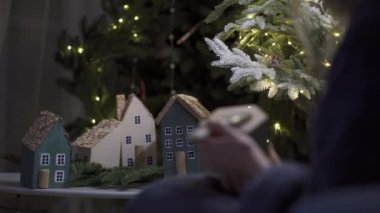 Yeni yıl ve Noel tatili için el yapımı güzel bir dekor. Bir kadın minyatür bir ev boyuyor. Yan görünüm