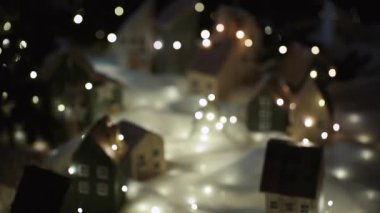 Noel arifesi. Güzel minyatür. El yapımı dekoratif köy. Bir tatil atmosferi hüküm sürüyor. Kamera hızla ilerler ve Noel ağacının durduğu köyün merkezinde durur..