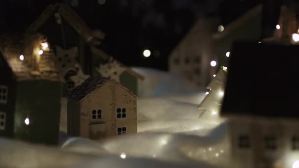 漂亮的缩影手工装饰的村庄 平安夜假日的气氛中 摄像机飞过市中心的小装饰房屋 雪和圣诞树 — 图库视频影像