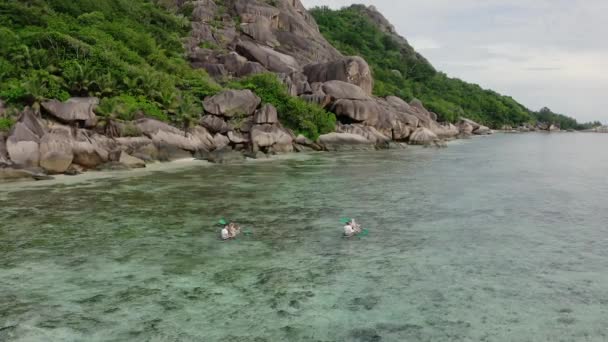一对年轻夫妇和他们的朋友乘坐透明的皮划艇航行 碧蓝的水色是不真实的美丽 从上面看 — 图库视频影像