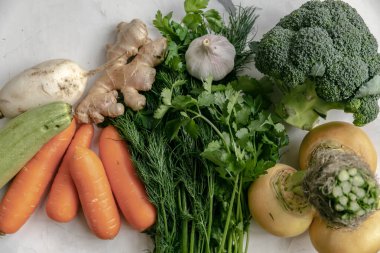 Yiyecek, sebze ve havuç. Şalgam, turp, brokoli, sarımsak, zencefil, dereotu, maydanoz, otlar. Sağlıklı yemek. Arka planda