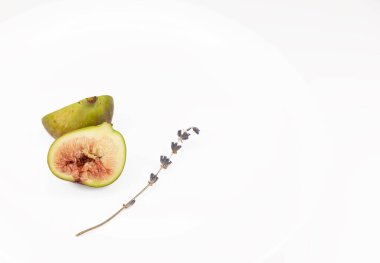 Tabakta incir. Dilimlenmiş incir ve lavanta çiçeği. İzole edilmiş. beyaz arkaplanda
