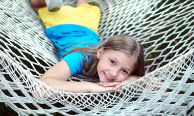  Kız yazın hamakta gülümser. Çocukluk mutluluğunun yaz konsepti                              