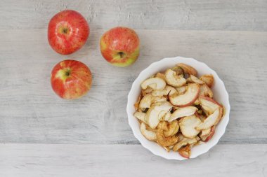 Masada üç elma ve elma tabağı var.
