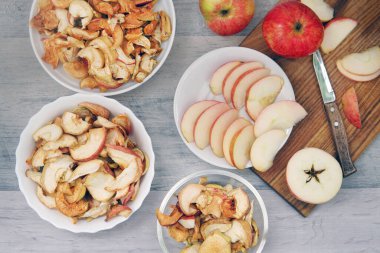 üç elma ve üç tabak kuru elma ve masada elmalar.