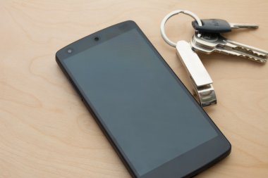 4g Smartphone wite evin anahtarı ahşap zemin üzerinde.