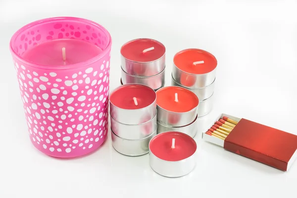 Velas vermelhas e rosa com caixa de fósforos no fundo branco — Fotografia de Stock