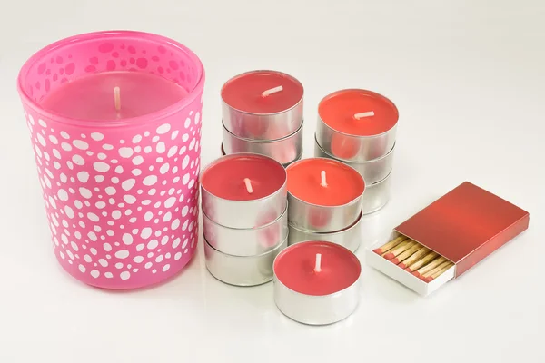 Velas vermelhas e rosa com caixa de fósforos no fundo branco — Fotografia de Stock