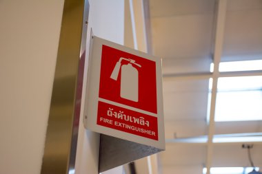 Red fire extinguisher sign in the large modern shopping mall clipart