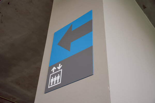 Сине-голубой знак лифта на пятом этаже автостоянки
.