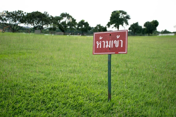 Ne pas entrer signe dans la langue thaï avec pelouse en arrière-plan — Photo