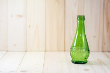 Yeşil cam şişeler ahşap tablo.