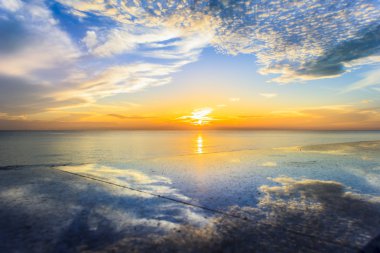 Deniz ve gölge gökyüzü bulutlar üzerinde gündoğumu.